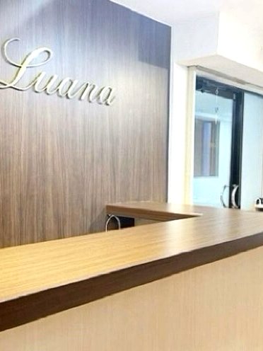 LUANA受付カウンター、木目とゴールドのロゴサイン